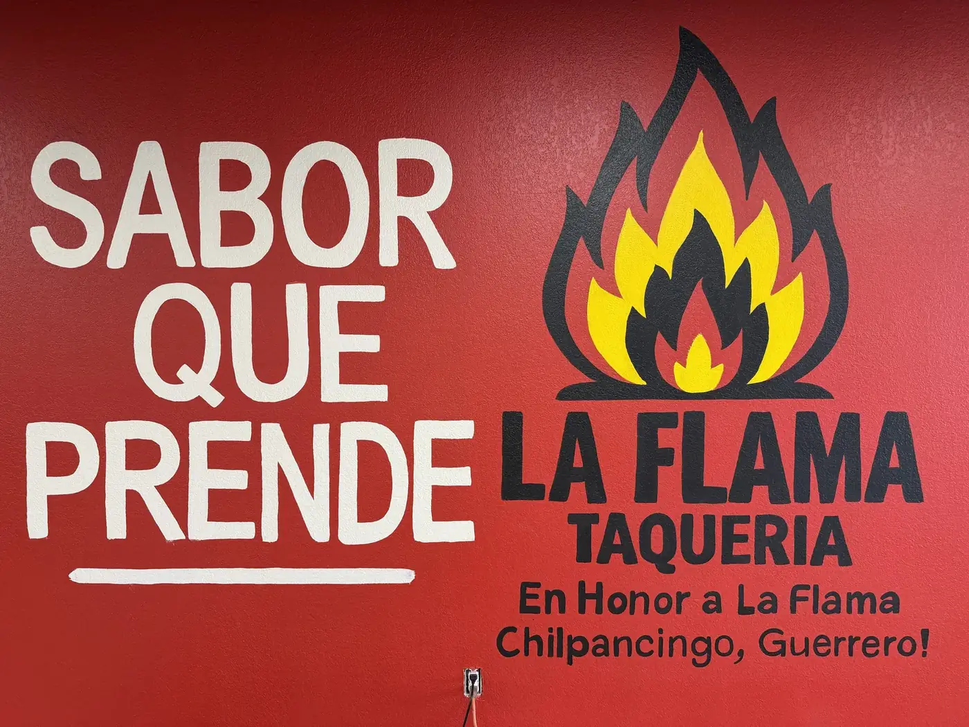 La Flama Taqueria mural with the flame logo and the words Sabor Que Prende and En Honor a La Flama, Chilpancingo, Guerrero
